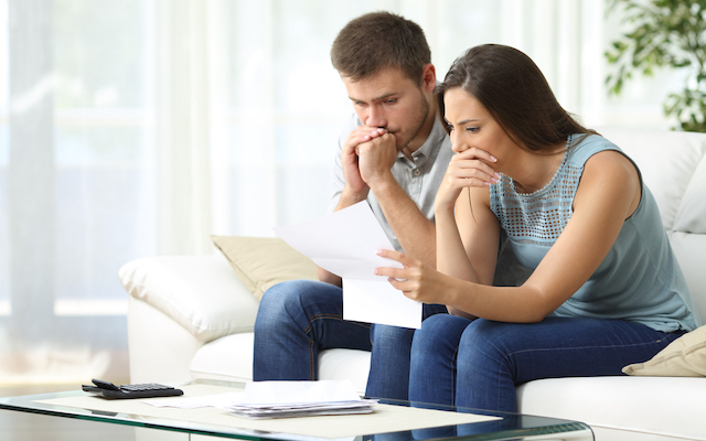 Worried couple reading a letter