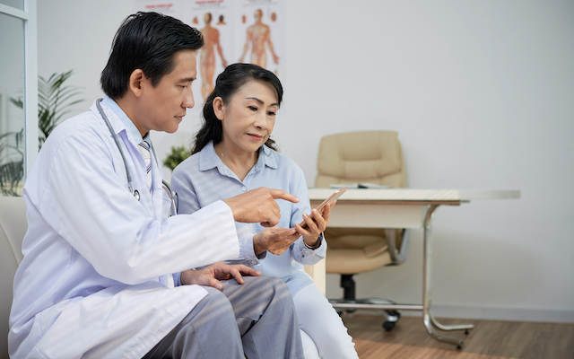 Doctor and patient look at smartphone