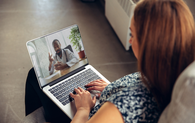 Close up of young woman talking to a doctor online