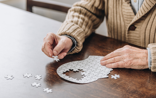 cropped view of senior man playing with puzzles