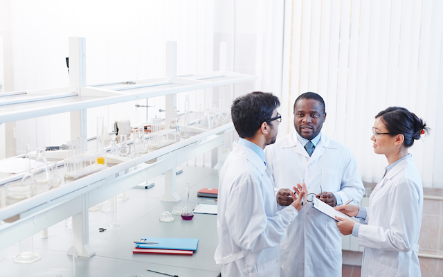 three scientists talking in laboratory