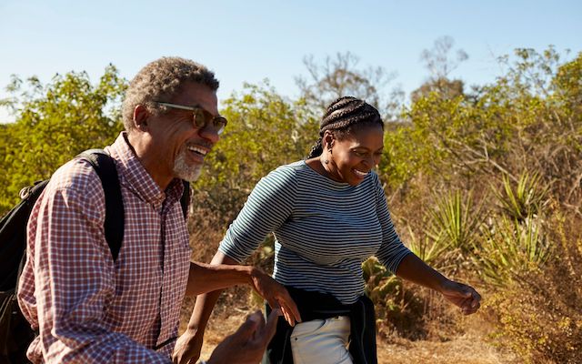 Two people hike outdoors on a sunny day