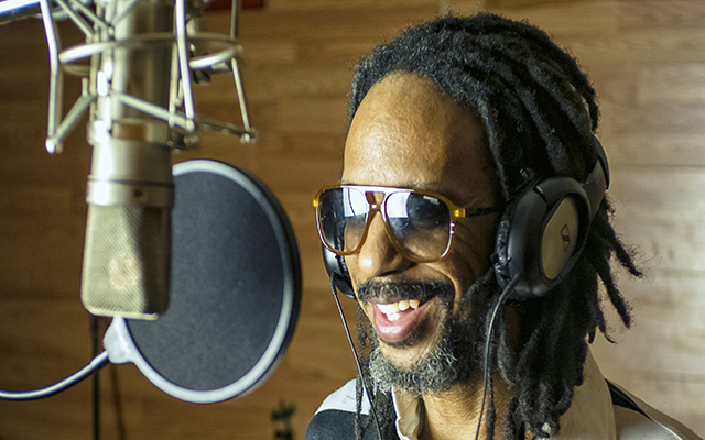 Walter J Archey III stands at a studio microphone.