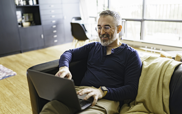 A Portrait of man with laptop on sofa