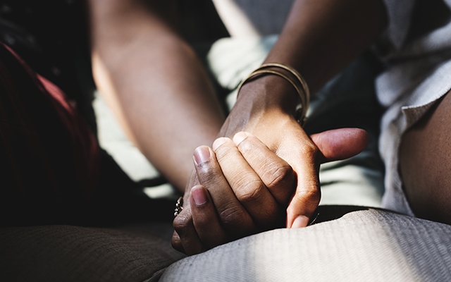 Closeup of couple holding hands