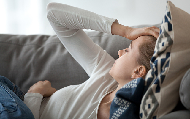 A woman lies on a couch.