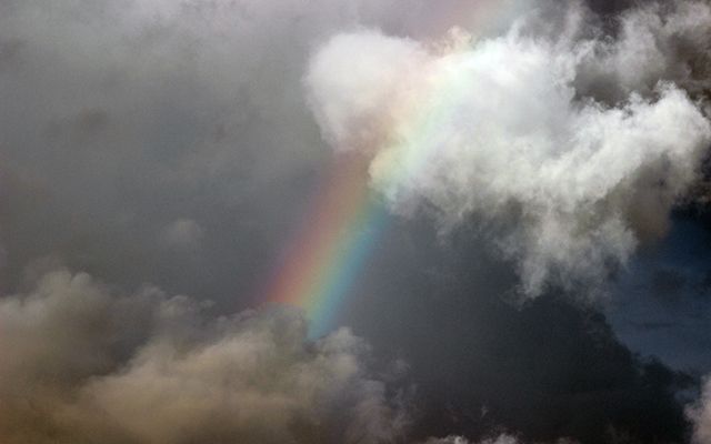 a rainbow between two clouds