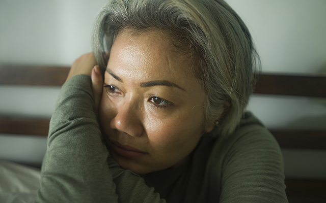 mature lady crisis - attractive middle aged woman with grey hair sad and depressed in bed feeling scared and lonely thinking worried about covid-19 virus pandemic during home lockdown