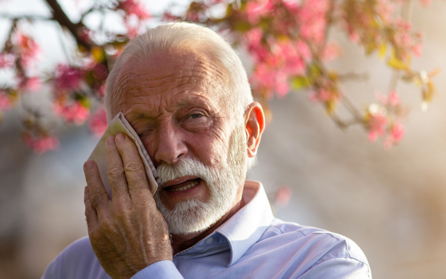 Man wiping eye