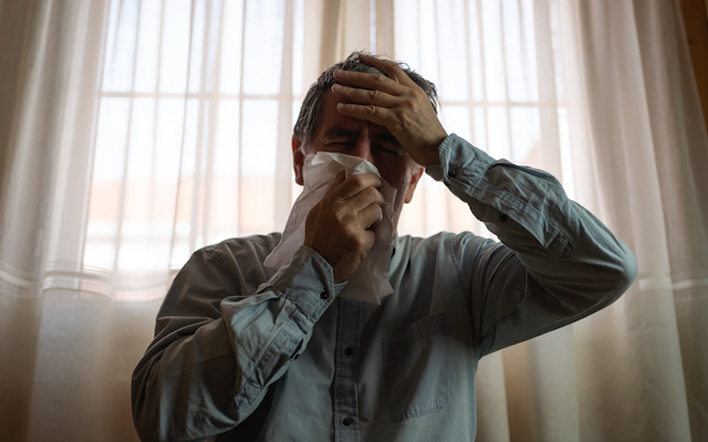 Man blowing his nose.