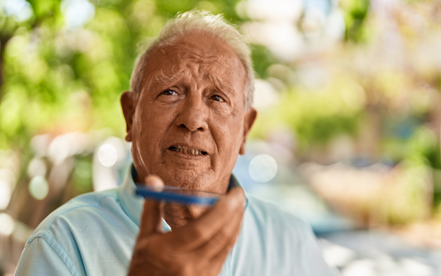 A picture of a man speaking into a mobile phone