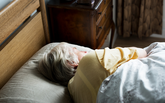 An elderly woman asleep in bed