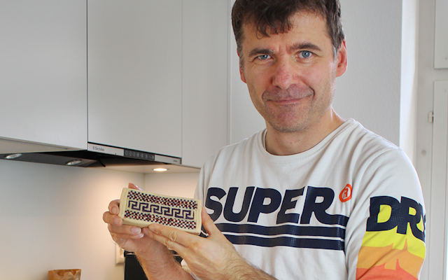 A photo of Urs Bratschi holding up pasta art