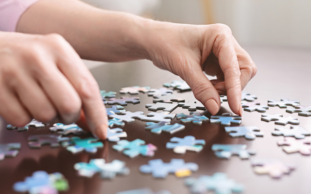 Close up of hands working on a puzzle