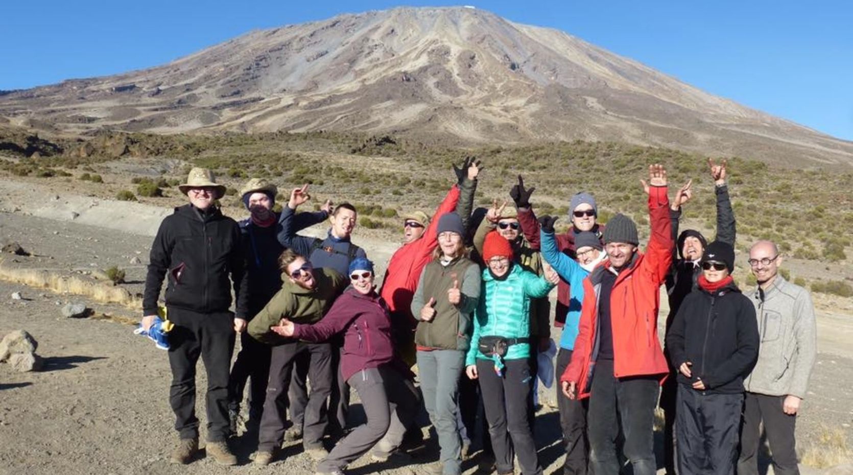 A photo of a Parkili "Moving Mountains for Parkinson's" expedition, with the group standing in front of Kilimanjaro in 2017
