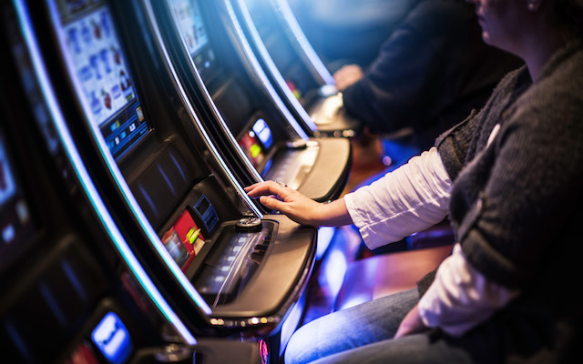 Casino Slot Gamblers. People Playing Video Slot Machines Inside Las Vegas Located Casino.