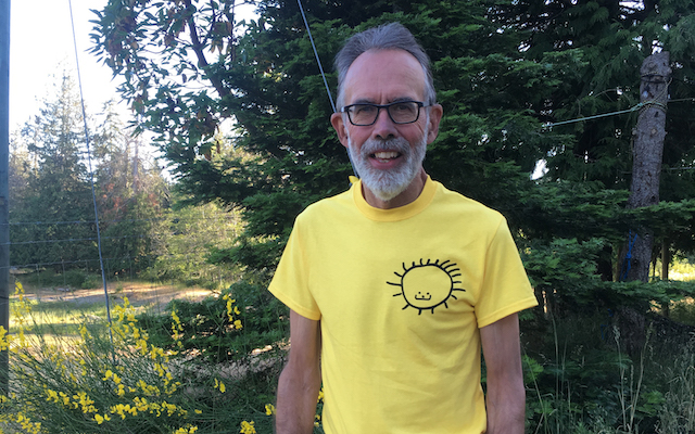 Blaine Kennedy poses for a photo backdropped by trees in nature