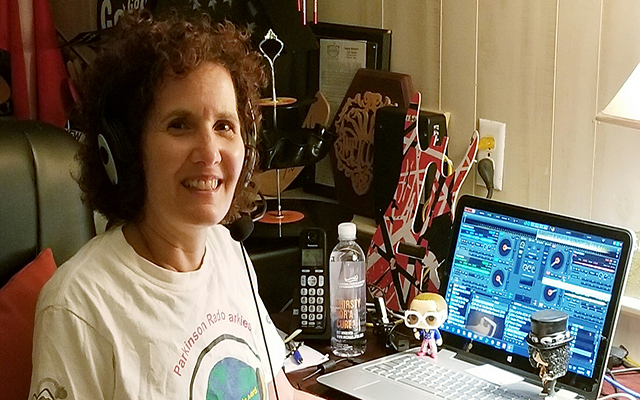 Laura Hanf wears headphones, sitting at her computer.