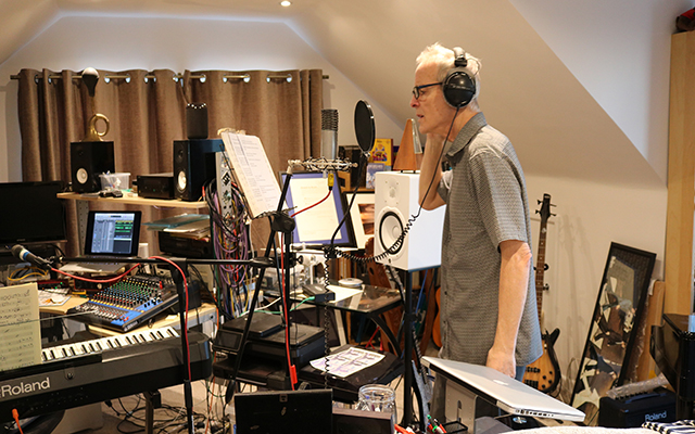 Tony Coffey records in a studio full of equipment.