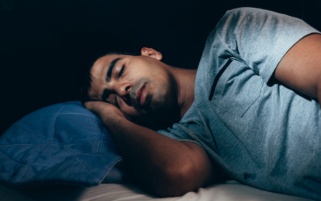 Young man sleeping in bed