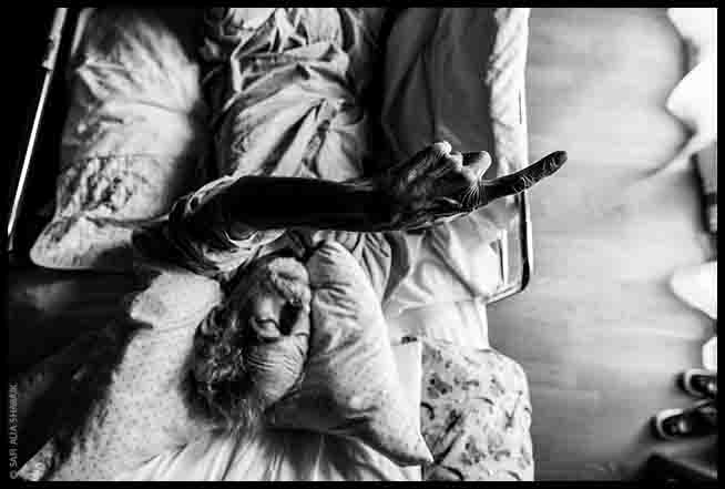 Aly Shabaik reaching out from his hospital bed.