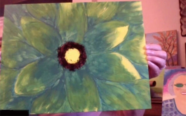 A participant in the class showing her painting on a zoom call